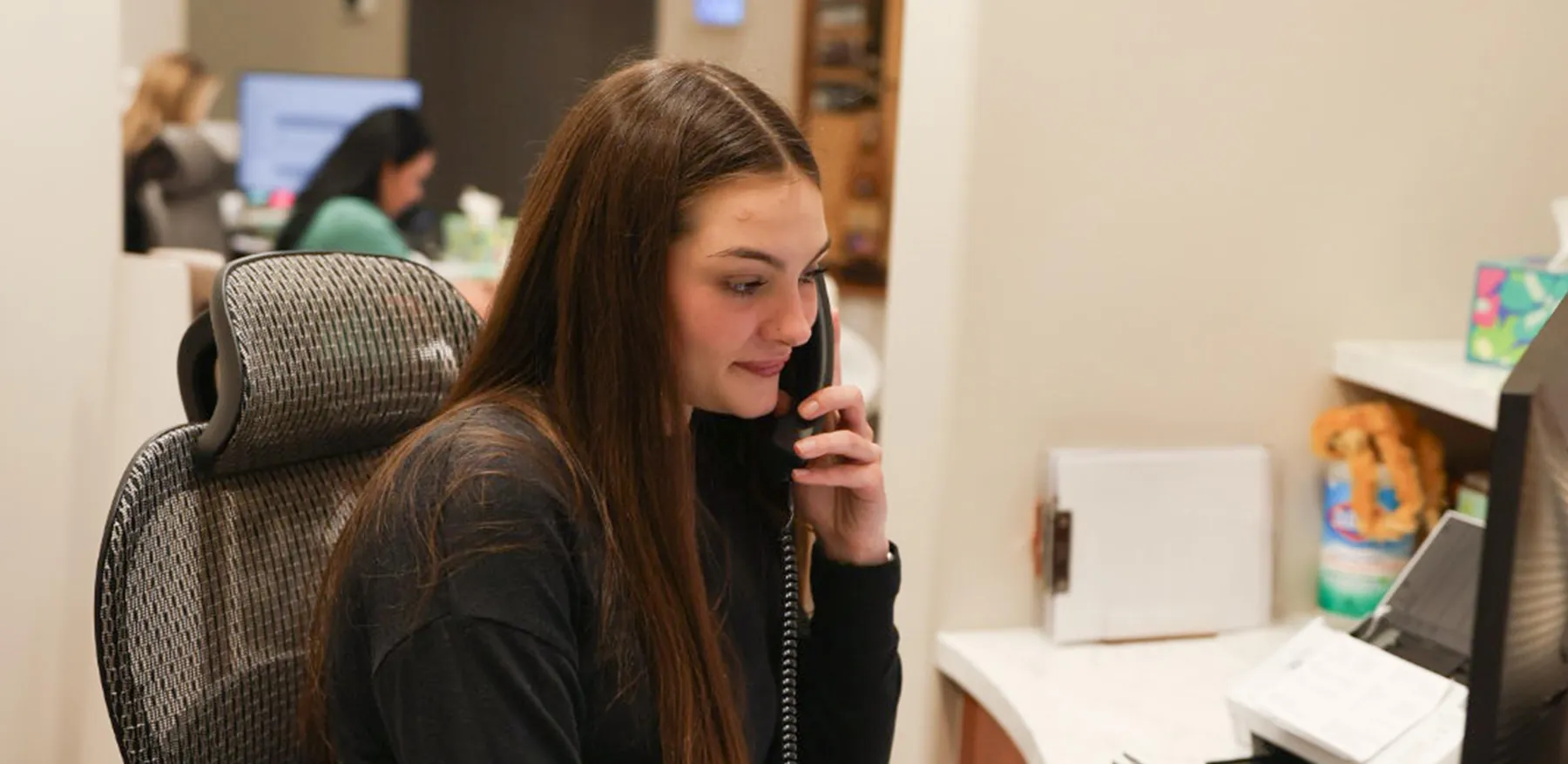 A team member answering the phone at the front desk